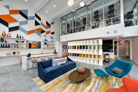 a living room with a blue couch and colorful chairs